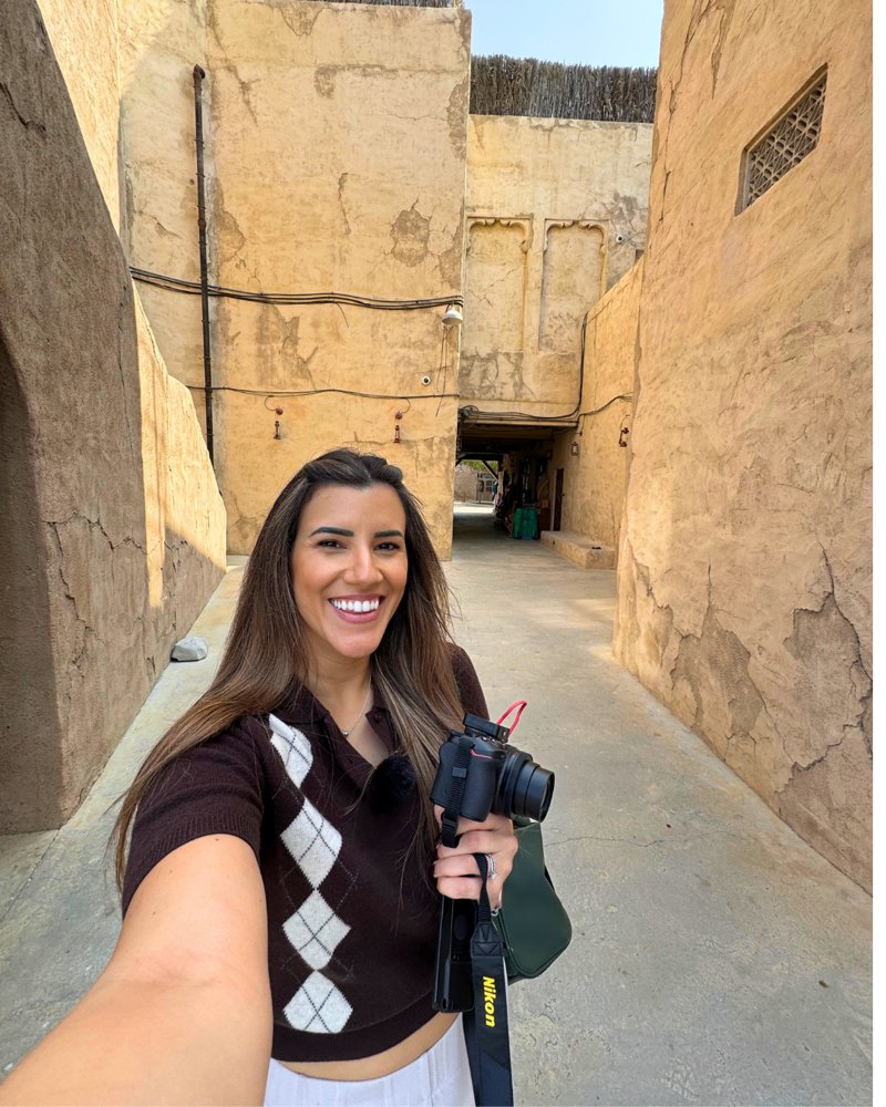Veronica filming a vlog in an old town alley in Dubai